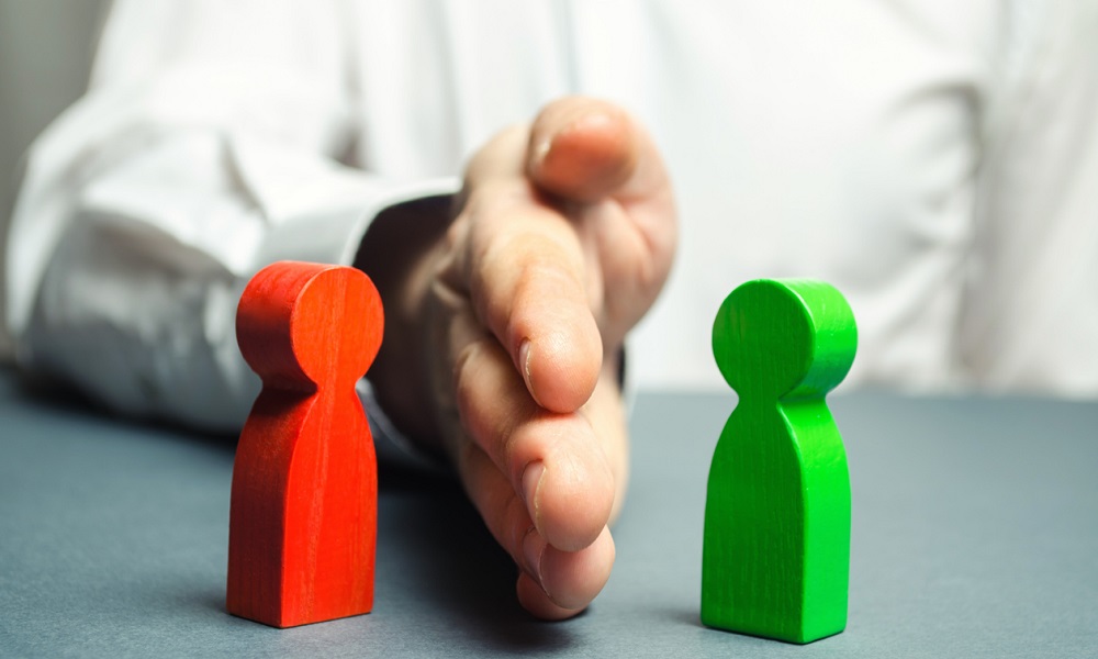 The person divides with the palm the red and green figures of people. Orbiter, the solution of controversial issues and conflicts of interest. Stop the conflict, the mediator. Dispute resolution.